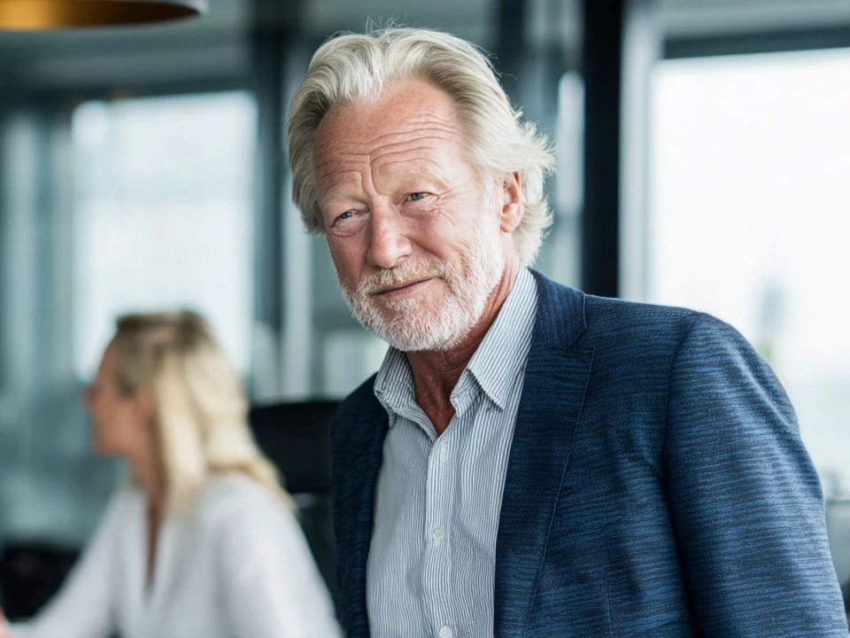 A senior partner listens with a sceptical half-smile in a busy consultancy office